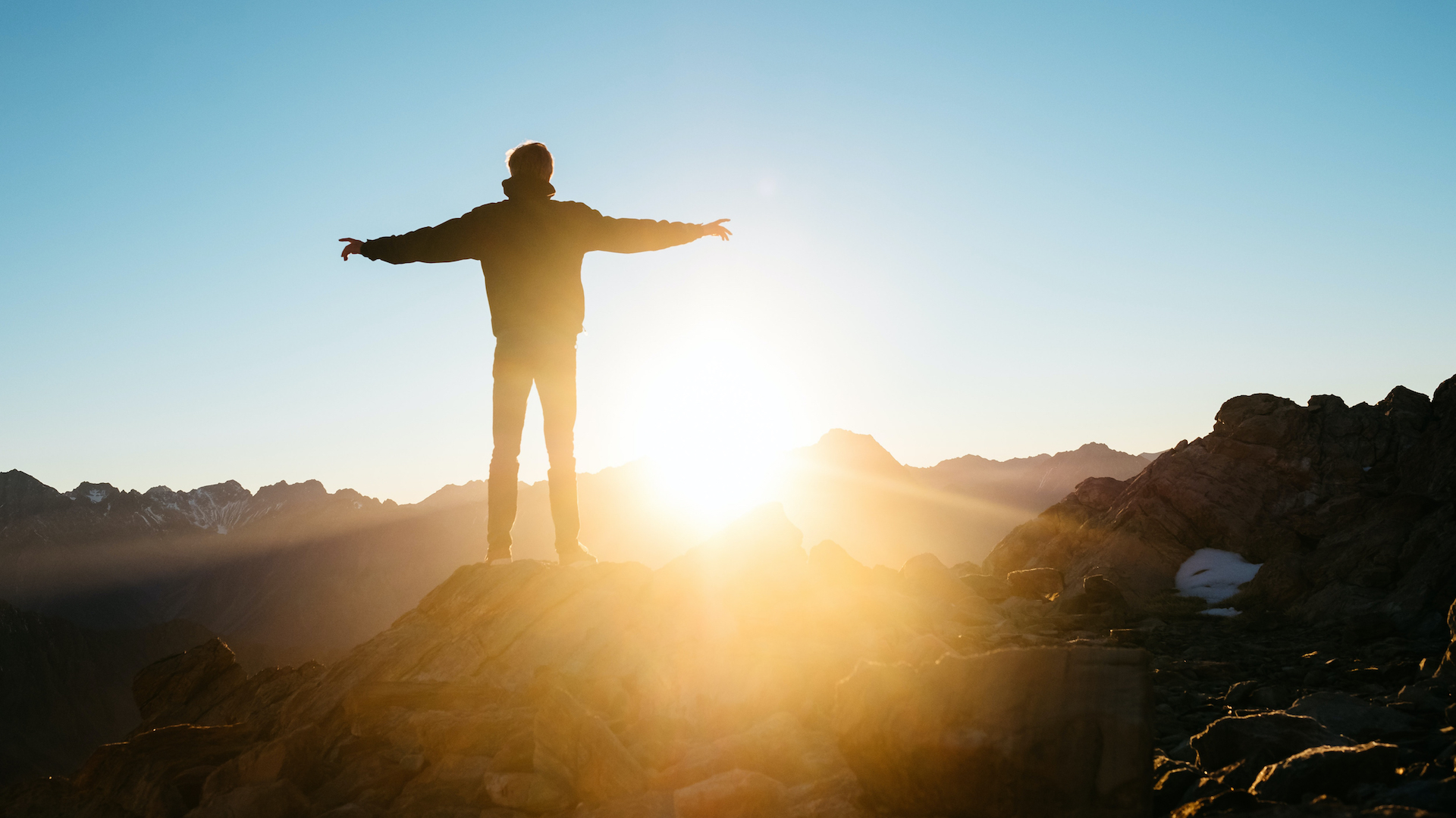 person standing on top of mountain with arms spread