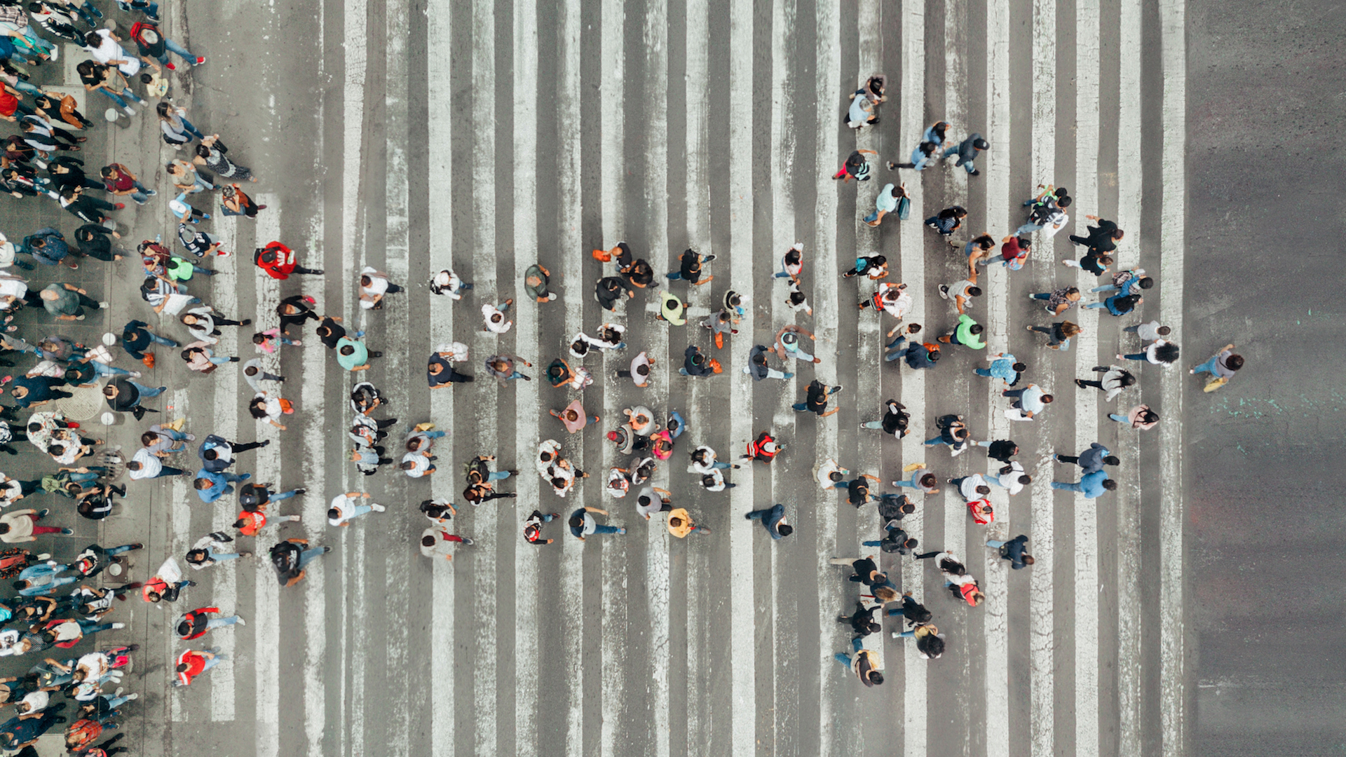 people walking in a the form of an arrow across street