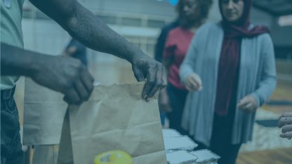 Man handing a food parcel to a woman