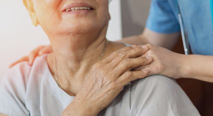 A caregiver puts their hands on a patient's shoulder