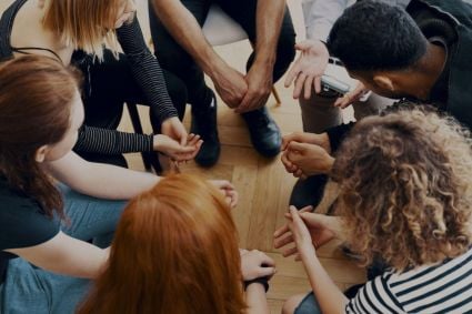 A group of people seated in what appears to be a therapy session