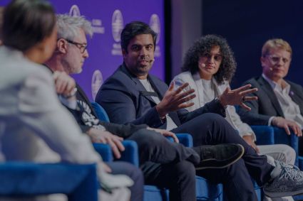 A group of people talking on a panel at a conference.