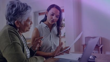 An older woman speaks to her doctor in front of a laptop.