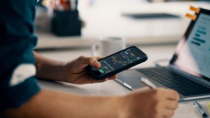 Close photo of a person's arm holding a smartphone.