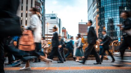 People crossing a busy street in a city.