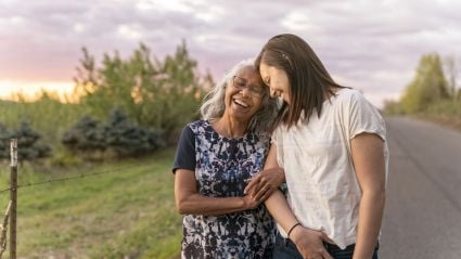 two women leaning on each other on a walk