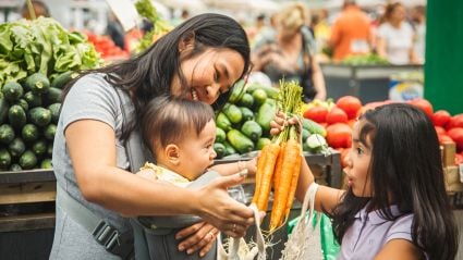 A mother and two young children in a grocery store.