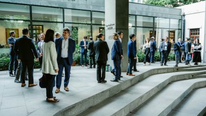 People standing outside of building dressed in business clothing 