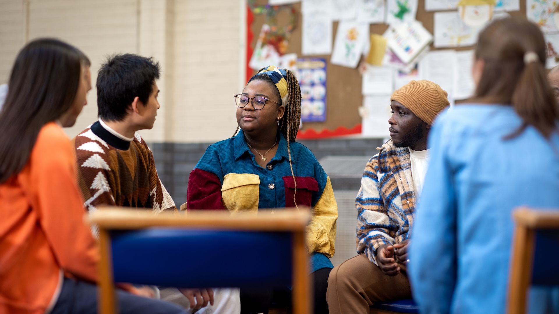 Five people sitting in a circle having a discussion