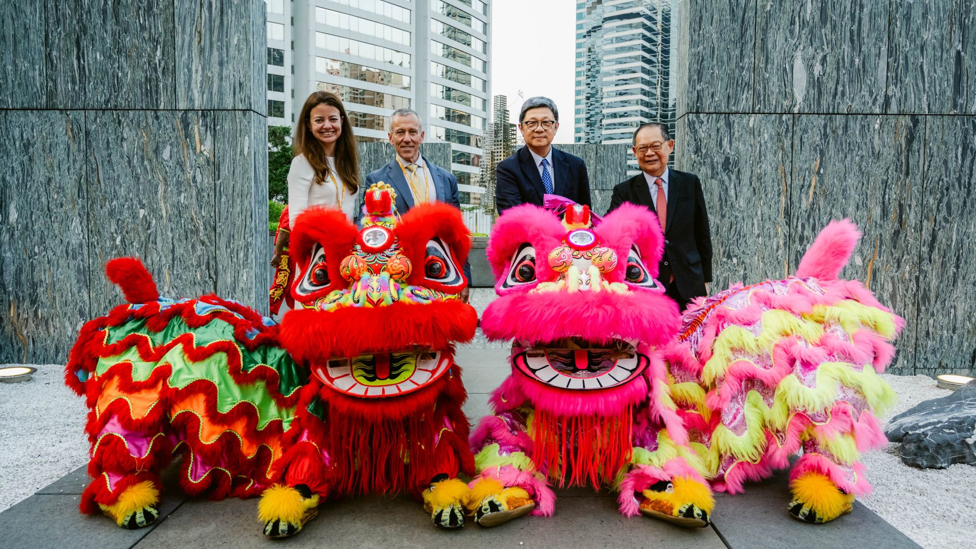 Four people stand behind Chinese dragon statues