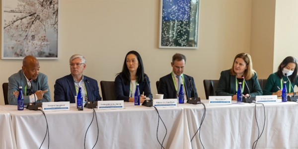 An image of six adults dressed in business attire sitting on a panel at a table with a white cloth. They are discussing the Future of Health and Aging and the image is a part of a newsletter around the Future of Aging.