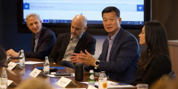 An image leading into a newsletter about the Future of Aging. It is of four adults in business attire sitting at a meeting table and having a discussion. There are 3 men and 1 woman.