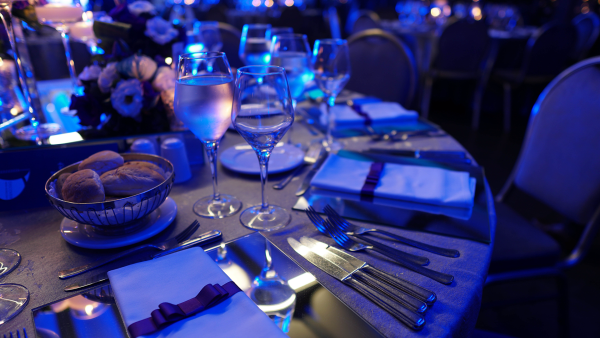 blue lit close up of dinner table at event