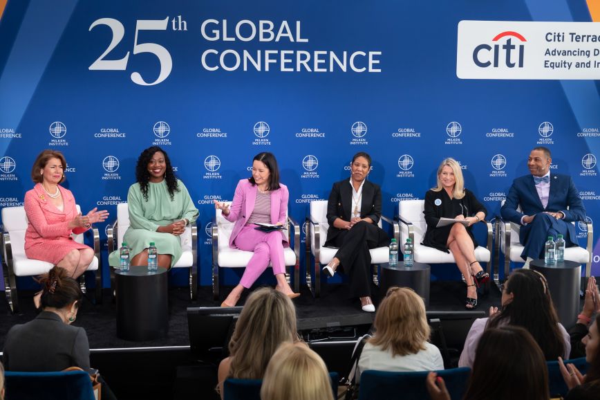 a panel of professional speakers in chairs having a discussion