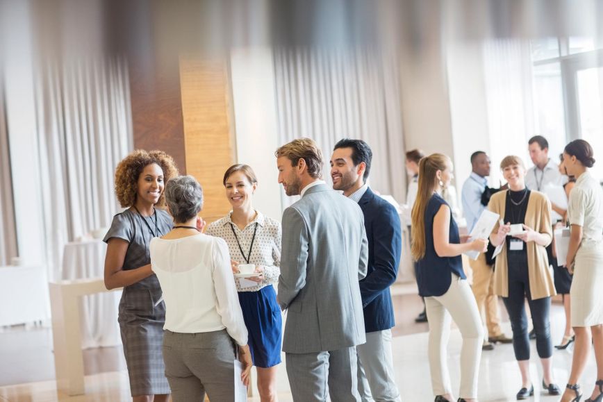 Several people in business attire networking at a conference