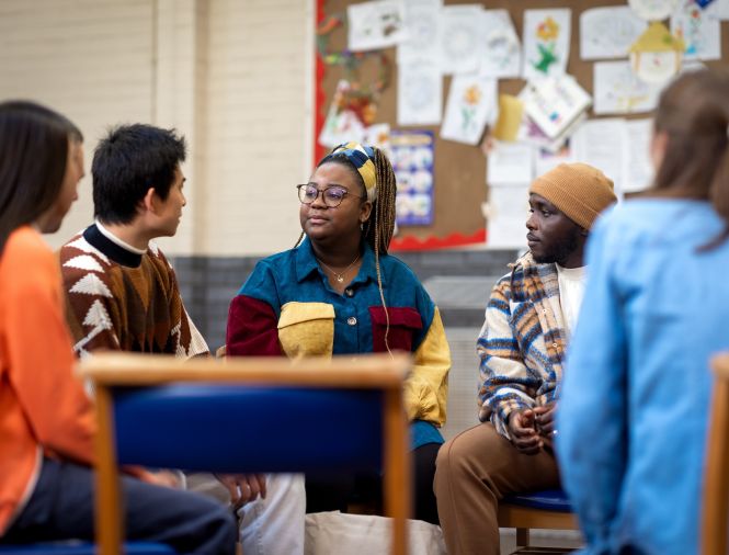 Five people sitting in a circle having a discussion