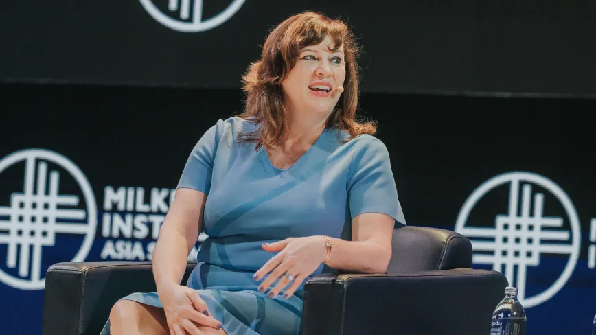 woman sitting in a chair on stage as a panel speaker