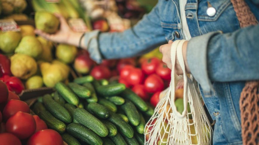 close up of person's arms picking out produce