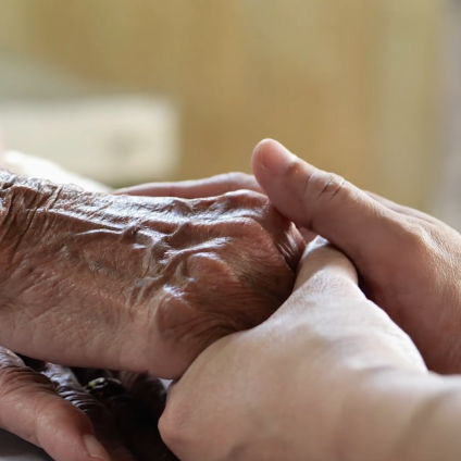 Two hands embracing, one young, one old