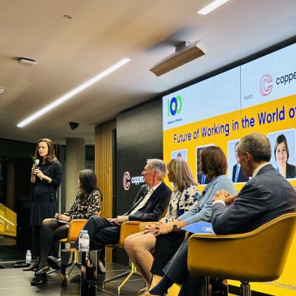 A group of people sit on stage during an event panel