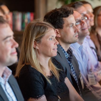 A group of people listen to a speaker at an event