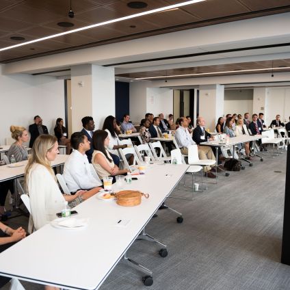 A group of people listen to a speaker at an event