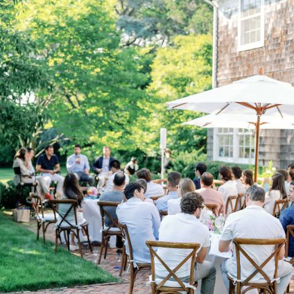 A group of people sit at tables outside during an event