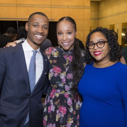 A group of three people pose for a photo