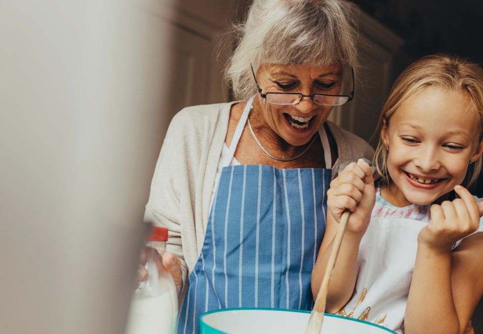 elderly woman and little girl baking together