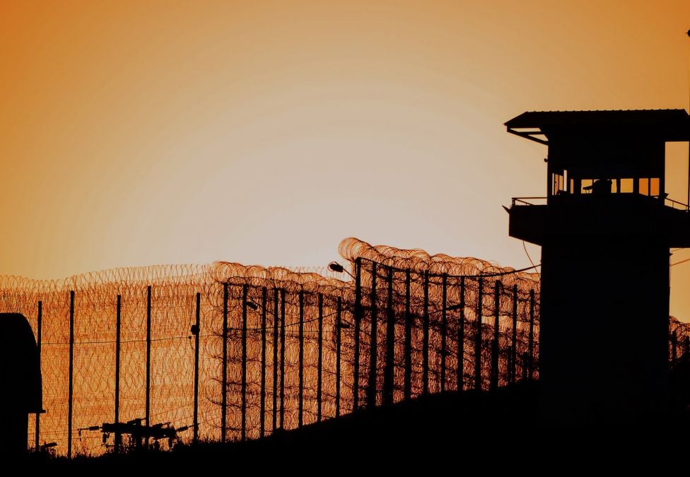 Prison gates and watchtower at dusk