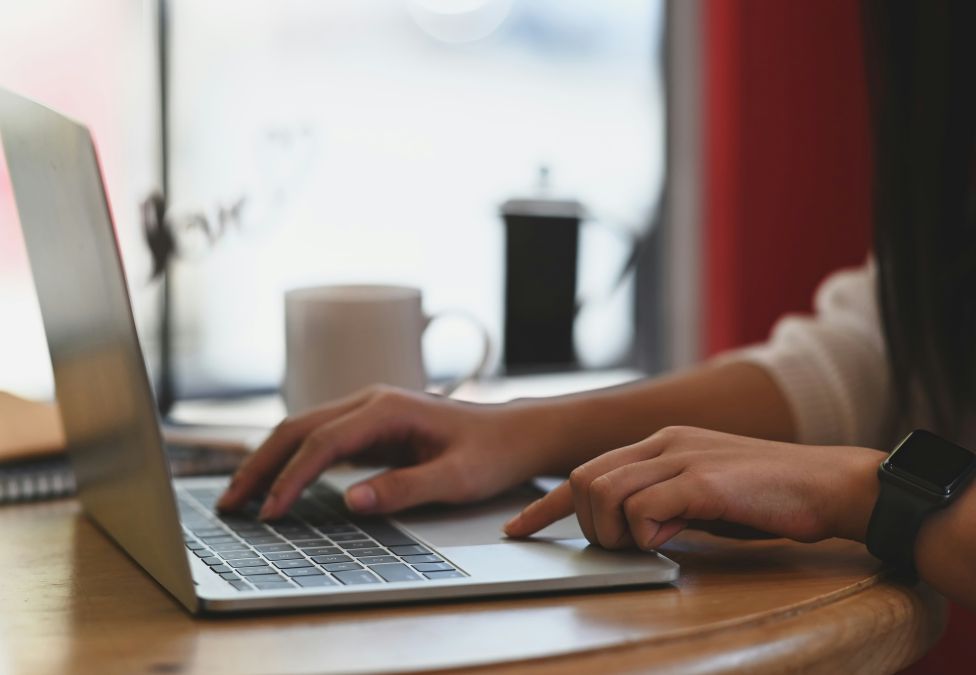 A person's hands at a laptop computer on a table