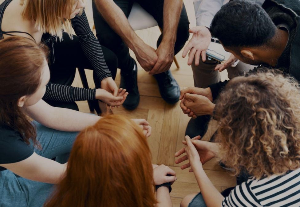 A group of people seated in what appears to be a therapy session