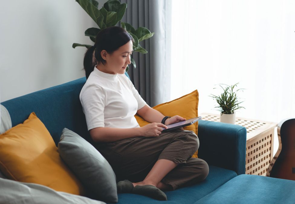 Woman sitting on a couch looking at her phone