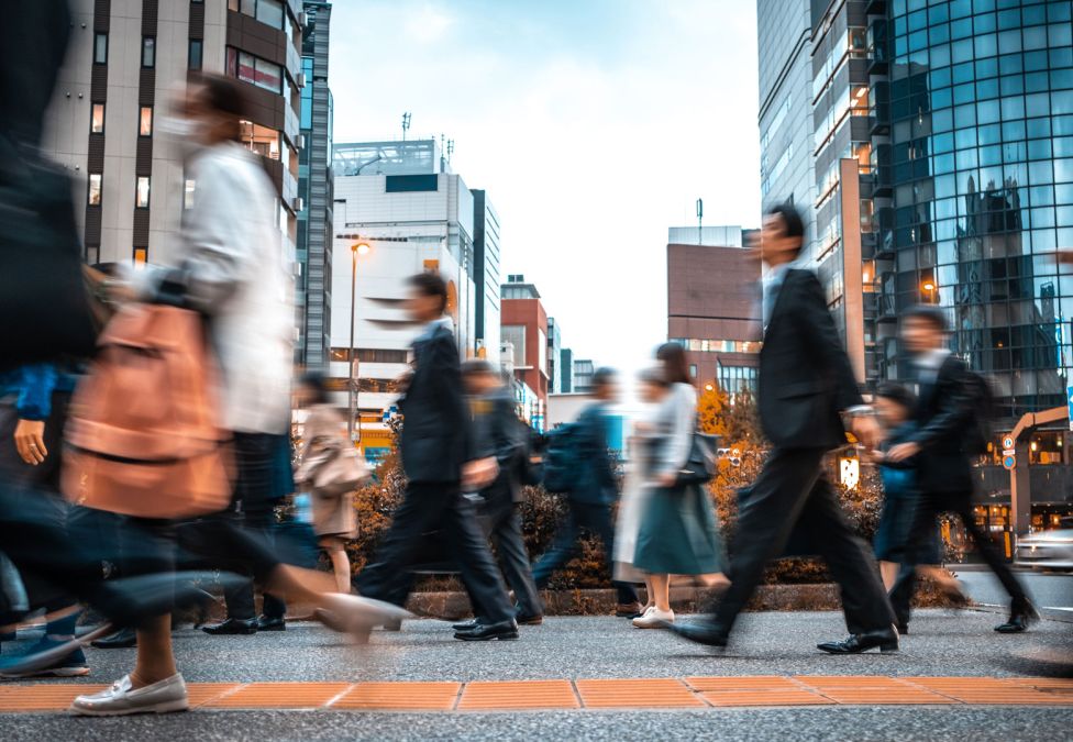 People crossing a busy street in a city.