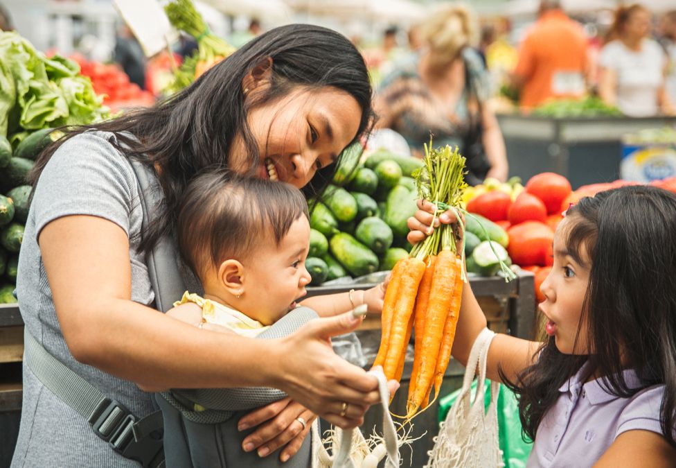 A mother and two young children in a grocery store.