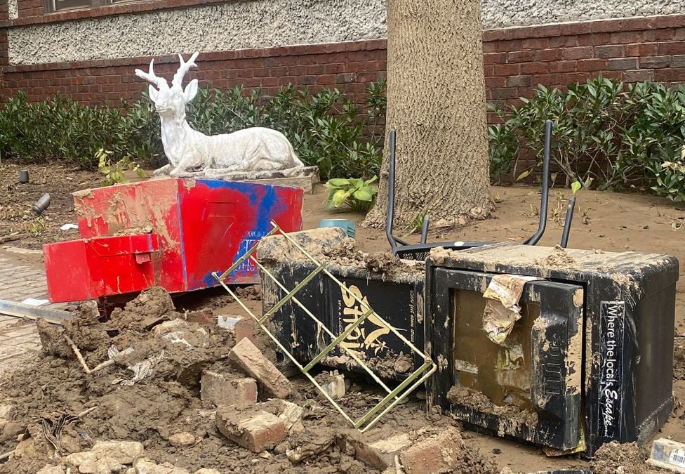 A pile of various rubbish items, mud, and rocks, leading into an article titled "Weather and Waste: Rethinking Small Business Support Following a Natural Disaster". 